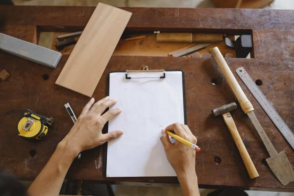 Crop artisan sketching on paper in workshop