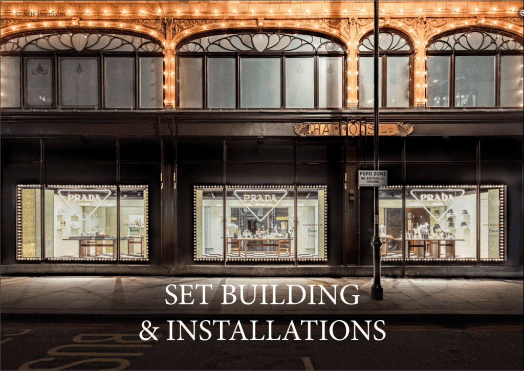 An elegant storefront at night, illuminated with warm lights, showcasing large display windows adorned with prada installations, under a sign reading "harrods." text overlay states "set building & installations.