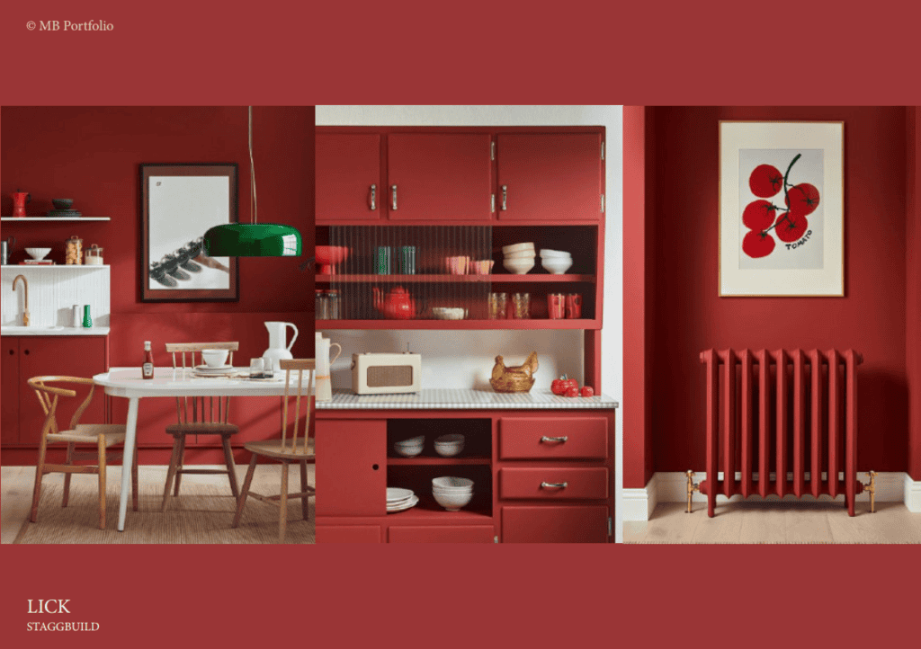 A stylish kitchen and dining area with red cabinetry, a white countertop, and a round table with chairs. also featured are open shelves with dishes and a vibrant red wall with a framed apple art piece.